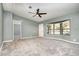 Bright living room with a ceiling fan, plush gray carpet, and bay window offering natural light at 1638 Leesburg Blvd, Fruitland Park, FL 34731