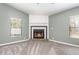 Comfortable living room featuring a corner fireplace, soft gray walls, and plush gray carpeting at 1638 Leesburg Blvd, Fruitland Park, FL 34731