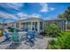 A backyard features a patio with Adirondack chairs, a fire pit, a sliding door, and lush landscaping at 17714 Se 84Th Sheldon Ter, The Villages, FL 32162