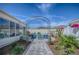 A backyard features a patio with Adirondack chairs, a fire pit, landscaping, and archway at 17714 Se 84Th Sheldon Ter, The Villages, FL 32162
