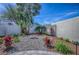 Landscaped backyard featuring rock garden, tropical plants, and white picket fence, creating a serene outdoor oasis at 17714 Se 84Th Sheldon Ter, The Villages, FL 32162