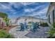 A backyard features a patio with Adirondack chairs, a fire pit, landscaping, and a privacy fence at 17714 Se 84Th Sheldon Ter, The Villages, FL 32162