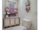 Charming powder room featuring a unique floral wall mural, decorative carved cabinet, and accent lighting at 17714 Se 84Th Sheldon Ter, The Villages, FL 32162