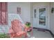 Inviting front porch featuring a decorative door and a cozy chair with a side table at 17714 Se 84Th Sheldon Ter, The Villages, FL 32162