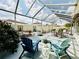 Enclosed patio with outdoor seating, lush landscaping, and a screened enclosure for year-round enjoyment at 17714 Se 84Th Sheldon Ter, The Villages, FL 32162