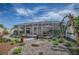 A screened-in patio features comfortable seating with a beautifully landscaped rock garden and paved pathway at 17714 Se 84Th Sheldon Ter, The Villages, FL 32162
