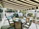 Inviting screened-in patio featuring a striped awning, outdoor dining set, and beautifully landscaped garden at 17714 Se 84Th Sheldon Ter, The Villages, FL 32162