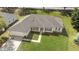 Single-story home with a spacious lawn, mature trees, a two-car garage, and a cozy front porch at 1792 Presidio Dr, Clermont, FL 34711