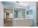 Light blue bathroom featuring a double sink vanity, large mirror, and glass shower at 1792 Presidio Dr, Clermont, FL 34711