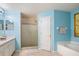 This bathroom features light blue walls, a white vanity, standing shower, and tub at 1792 Presidio Dr, Clermont, FL 34711