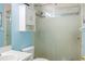 Bathroom with a glass door shower and white storage cabinet above the toilet at 1792 Presidio Dr, Clermont, FL 34711