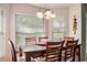 Sunlit dining area with a dark wood table, seating for six, and large windows at 1792 Presidio Dr, Clermont, FL 34711