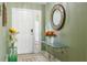 Charming foyer featuring decorative mirror, flower arrangement, and decorative glass side door panel at 1792 Presidio Dr, Clermont, FL 34711