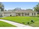 A single-story home boasts lush green lawn, side entry two-car garage, and a charming front porch at 1792 Presidio Dr, Clermont, FL 34711