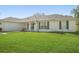 Charming single-story home featuring a lush green lawn, dark shutters, and a pristine white exterior at 1792 Presidio Dr, Clermont, FL 34711