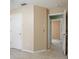 Hallway with beige walls, carpeted floors, and doorways leading to other rooms at 1792 Presidio Dr, Clermont, FL 34711