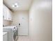 Laundry room featuring a washer, dryer, cabinets, and exterior door at 1792 Presidio Dr, Clermont, FL 34711