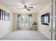 Bright living room with ceiling fan, neutral carpet, and large window with light blue curtains at 1792 Presidio Dr, Clermont, FL 34711