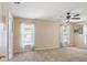 Bright living room with neutral carpet, ceiling fan, and light blue curtains at 1792 Presidio Dr, Clermont, FL 34711