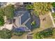 Aerial view of a home with solar panels, a well-maintained lawn, and mature trees at 181 Sutter Dr, Clermont, FL 34711