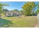 Spacious backyard featuring a well-maintained lawn, mature trees, and a screened in porch at 181 Sutter Dr, Clermont, FL 34711