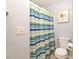 The bathroom features a toilet and shower with blue and green striped curtain at 181 Sutter Dr, Clermont, FL 34711