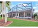 The backyard offers a screened-in pool, lush lawn, and landscaping at 20755 Queen Alexandra Dr, Leesburg, FL 34748