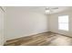 Neutral bedroom with natural light, wood-look floors, a ceiling fan, and a double door closet at 20755 Queen Alexandra Dr, Leesburg, FL 34748
