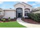 Inviting front entrance with a curved walkway and lush landscaping at 20755 Queen Alexandra Dr, Leesburg, FL 34748