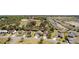 Wide aerial view of the property set amongst mature trees and a pond at 2082 Harston Trl, The Villages, FL 32162