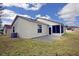 Back exterior view featuring a screened patio and an adjacent concrete patio perfect for outdoor seating at 2082 Harston Trl, The Villages, FL 32162