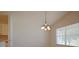 Bright dining area adjacent to the kitchen with a hanging chandelier and a large window at 2082 Harston Trl, The Villages, FL 32162