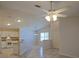 Open-concept living space with high ceilings, a fan, and modern flooring flows to the kitchen at 2082 Harston Trl, The Villages, FL 32162