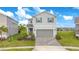 Charming two-story home features a gray exterior, blue shutters, a two-car garage, and a well-manicured lawn at 2116 Lelani Cir, Davenport, FL 33897