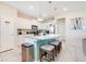 Bright kitchen featuring a granite island with seating, white cabinets, and stainless steel appliances at 2116 Lelani Cir, Davenport, FL 33897