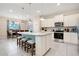 Modern kitchen with a large island, granite countertops, stainless steel appliances, and an adjacent dining area at 2116 Lelani Cir, Davenport, FL 33897