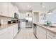 Bright kitchen features stainless appliances, granite countertops, and white cabinets offering a clean modern aesthetic at 2116 Lelani Cir, Davenport, FL 33897