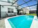 Inviting pool area with a screened enclosure, safety fence, and comfortable lounge chairs for relaxation at 2116 Lelani Cir, Davenport, FL 33897