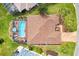 A high-angle shot showing a screened in pool and well-manicured landscaping and mature palm trees at 2126 Sansores St, The Villages, FL 32159