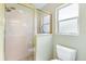 A pristine bathroom featuring a glass-enclosed shower and a bright, frosted window at 2126 Sansores St, The Villages, FL 32159