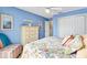 A cheerful bedroom with blue walls, a ceiling fan, and ample closet space at 2126 Sansores St, The Villages, FL 32159