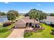 Beautiful tan home on the golf course with well manicured lawn, decorative fountain, and mature palm trees at 2126 Sansores St, The Villages, FL 32159