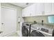 A functional laundry room with modern front-loading washer and dryer and lots of storage at 2126 Sansores St, The Villages, FL 32159