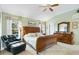 Inviting main bedroom featuring a ceiling fan, sitting area, and wooden furniture at 2126 Sansores St, The Villages, FL 32159