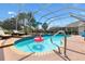 Screened in pool with flamingo float, lounge chairs, and outdoor dining space at 2126 Sansores St, The Villages, FL 32159