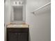 Half bathroom with a dark vanity, beige countertop, and a rectangular mirror at 213 Primrose Dr, Davenport, FL 33837