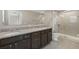 Bathroom featuring double sinks with granite countertop, framed mirror, and glass enclosed shower at 213 Primrose Dr, Davenport, FL 33837