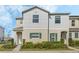 Inviting two-story townhouse with light gray siding, green shutters, and well-manicured shrubbery at 213 Primrose Dr, Davenport, FL 33837