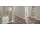 Hallway with wood floors, leading to a laundry room, and stairs to lower level at 213 Primrose Dr, Davenport, FL 33837
