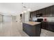 Open concept kitchen with dark cabinets, granite countertops, and a central island at 213 Primrose Dr, Davenport, FL 33837